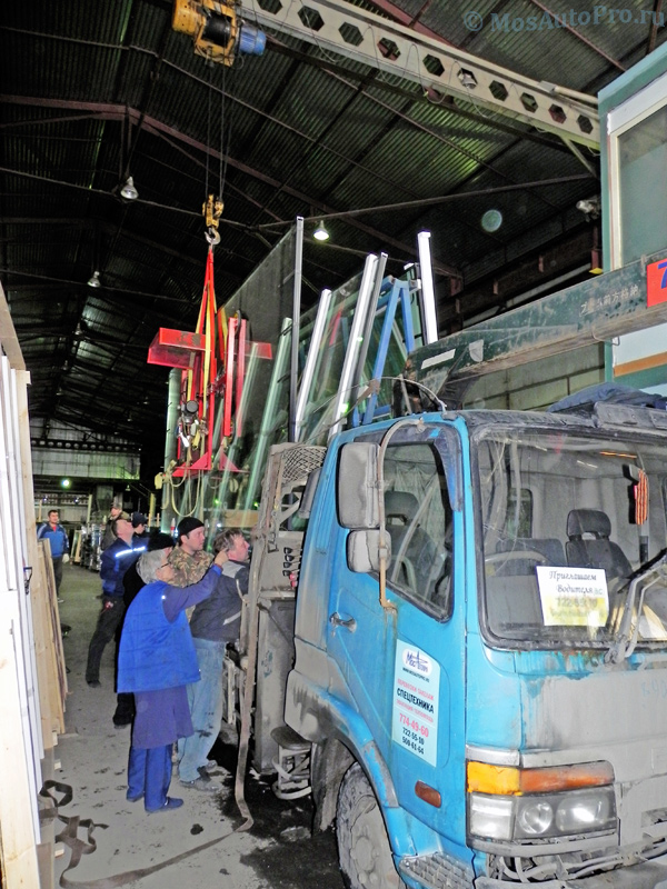 Погрузка больших стеклопакетов размером 5,98 на 2,98 метра и весом более 1 тонны каждый крановым вакуумным подъемником на платформу манипулятора в городе Дзержинский.