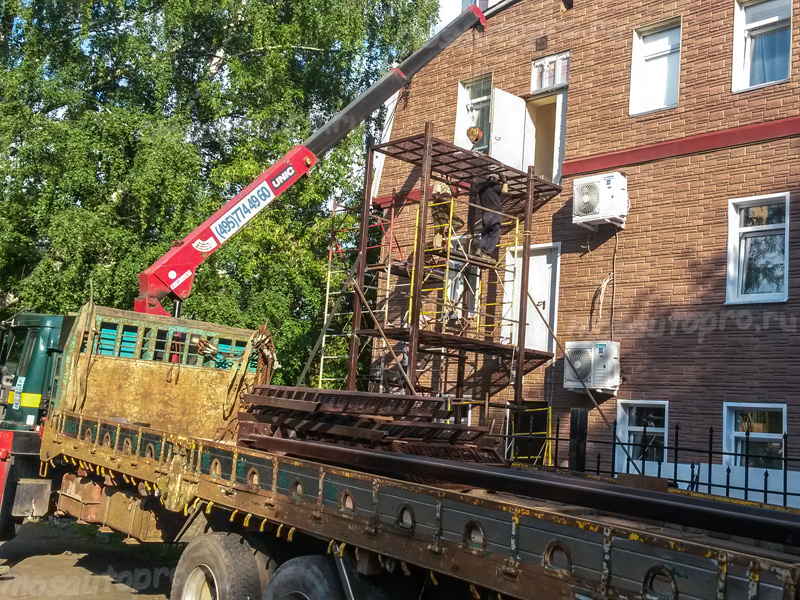 Перевозка и монтаж металлической пожарной запасной лестницы 3 этажного здания манипулятором.