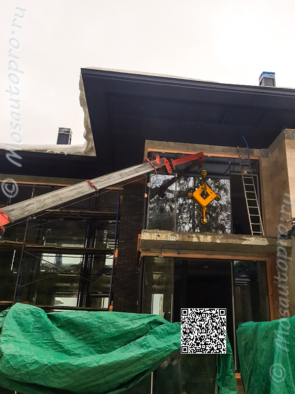 Монтаж стеклопакета 3х2 метра на уровне 2 этажа с помощью манипулятора длинной стрелой с удлинителем и автономной вакуумной присоской под козырьком здания.