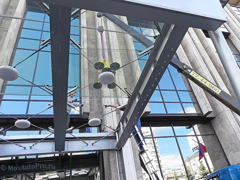 Монтаж тяжелого витринного стекла с использованием вакуумной присоски козырька здания НБ ТРАСТ.