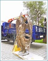 Перевозка скульптуры Архангела с мечем машиной с краном манипулятором.