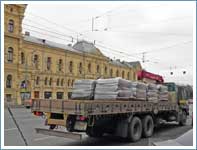 Перевозка рулонных газонов на поддонах манипулятором длинномером в центре Москвы.