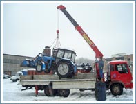 Погрузка трактора Беларусь машиной с краном манипулятором.